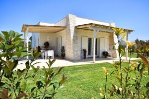 een huis met een patio en een grasveld bij Borgo Fiorito Relais in Parabita
