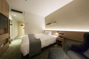 a hotel room with a bed and a couch at Shizutetsu Hotel Prezio Kyoto Shijo in Kyoto