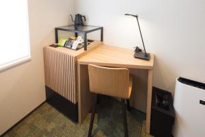 a desk with a chair and a lamp on it at Shizutetsu Hotel Prezio Kyoto Shijo in Kyoto