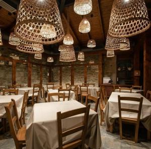 a dining room with white tables and chandeliers at Pensión Biazteri in Laguardia