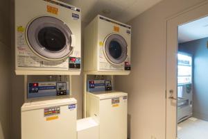a laundry room with washers and dryers on the wall at Shizutetsu Hotel Prezio Kyoto Shijo in Kyoto