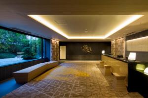 a hotel lobby with a couch and a large window at Shizutetsu Hotel Prezio Kyoto Shijo in Kyoto