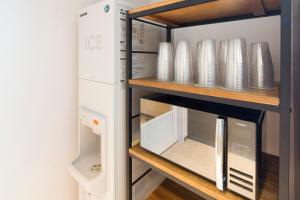 a cupboard filled with plates and other dishes at Shizutetsu Hotel Prezio Kyoto Shijo in Kyoto