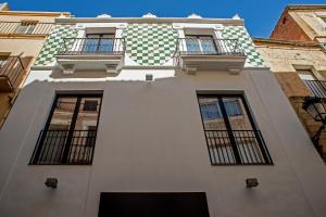 un edificio bianco con finestre e balconi di Apartamentos Turísticos Moret 11 - 1C a Cáceres