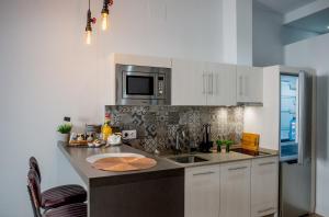 a kitchen with a sink and a microwave at Apartamentos Turísticos Moret 11 - 1C in Cáceres