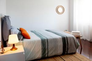 ein Schlafzimmer mit einem Bett und einem Tisch mit einer Lampe in der Unterkunft Canido, Vigo, Rias Baixas in Oya