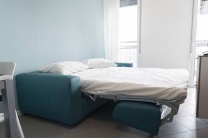 ミラノにあるPolitecnico Chique Apartmentの青い椅子2脚が備わる部屋の病院ベッド1台