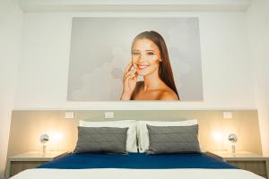 un poster di una donna appeso sopra un letto di BeeApartments a Bari