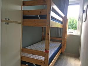- deux lits superposés dans une chambre avec fenêtre dans l'établissement Chalet Boerennest - Heerlijk chalet met overkapt terras en 3 slaapkamers - max 5 pers - 3 km van Noordzee - locatie op camping Moorhoek 10, à Rockanje