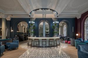 a hotel lobby with a bar in the middle at The Clermont London, Victoria in London