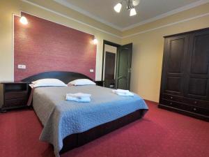 Casa Bucovineana في سوسيفا: غرفة نوم بسرير كبير عليها مناشف