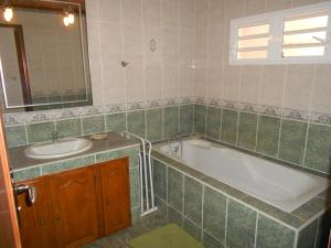 ein Badezimmer mit einer Badewanne und einem Waschbecken in der Unterkunft CHEZ JACQUELIN ET DORLYS in Saint-André