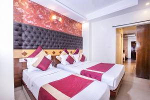 ein Hotelzimmer mit 2 Betten und einer Wand in der Unterkunft Aishwarya Residency in Mysore