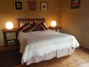 een slaapkamer met een bed met twee lampen op twee tafels bij Over The Mountain Guest Farm in George