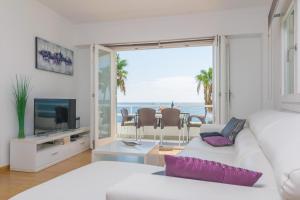 una sala de estar blanca con vistas al océano en Ses Roques de Cala Bona, en Son Servera