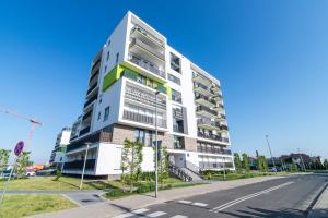 a tall white building on the side of a street at LuxApart Kalisz V.I.P in Kalisz