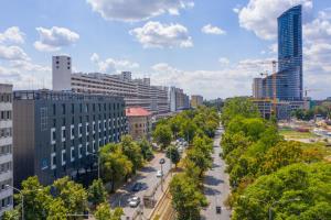 a city with tall buildings and a street with trees at Q Hotel Plus Wrocław in Wrocław