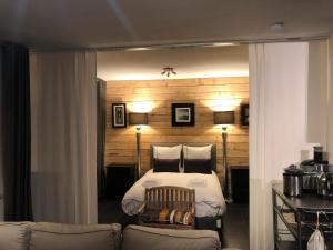 プルガヌーにあるRésidence De La Baieのベッドルーム1室(ベッド1台、ランプ2つ、ソファ付)