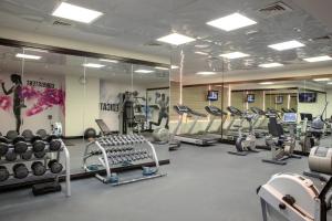 a gym with treadmills and machines in a room at Jumeira Rotana – Dubai in Dubai