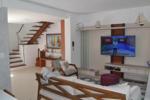 a living room with a couch and a tv at Paraiso Praia de Imbassai - Ykutiba S-001 - Duplex frente mar in Imbassai