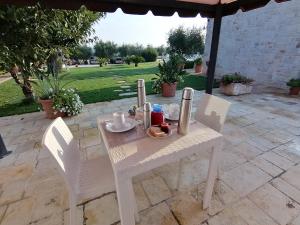 a white table and chairs on a patio at Trulli Dal Conte in Locorotondo