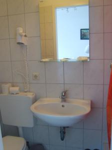 a bathroom with a sink and a toilet and a mirror at Hotel Wandsbek Hamburg in Hamburg
