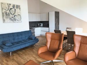 a living room with a couch and a table and chairs at Ferienwohnungen Thum in Rosenheim