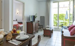 貝格海姆的住宿－Résidence Odalys Le Domaine des Rois，客厅配有桌子、沙发和电视。