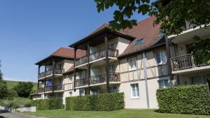 an apartment building with balconies and bushes at Résidence Odalys Le Domaine des Rois in Bergheim