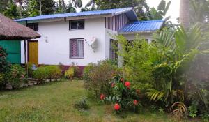una casa bianca con tetto blu di "Dulce Hogar" homestay a Majuli