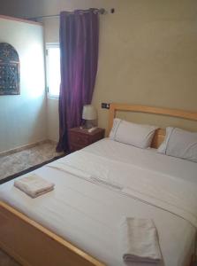 a bedroom with a large white bed with a window at Bio Palace Hotel in Tinerhir