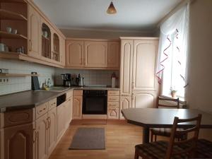 a kitchen with white cabinets and a table and a window at Gästewohnung Starsiedel in Lützen