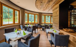 un restaurant avec des tables, des chaises et des fenêtres dans l'établissement Gasthof Furtner, à Rohr im Gebirge