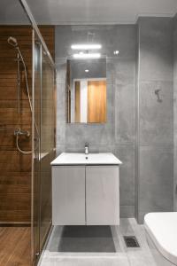 a bathroom with a white sink and a shower at #Luxlikehome - Cozy Living Thessaloniki in Thessaloniki