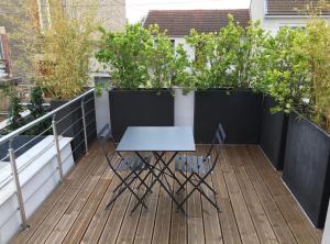 - Balcón con mesa blanca y sillas en La Petite Maison de Jane en Reims