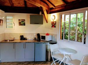 uma cozinha com um balcão, uma mesa e cadeiras em Chalet "BIENVENUE NOUT KAZ" em Saint-Gilles-les Hauts
