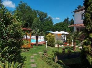 a yard with a swimming pool and a house at Hotel Schmid in Bad Bellingen
