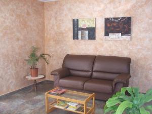 ein Wohnzimmer mit einem Sofa und einem Tisch in der Unterkunft Hostal Casa Juan in Lorca
