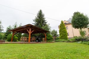 a wooden gazebo with a grill in a yard at Apartmány PEMI Potštejn in Potštejn