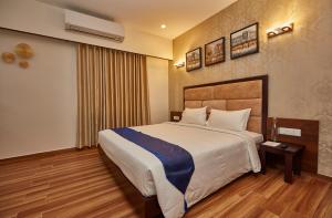 a hotel room with a large bed and a window at The Continentti Whitefield in Bangalore
