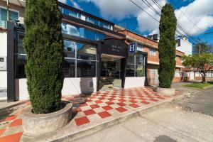 una tienda frente a dos árboles frente a un edificio en Hotel Ejecutivo Embajada, en Bogotá