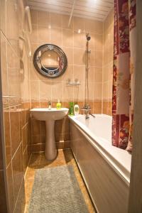 a bathroom with a sink and a tub and a mirror at LAFLATS Volkhonka in Moscow