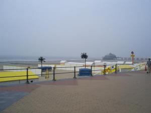 a boardwalk with yellow ramps and the beach at residentie leopold app 21 in Blankenberge