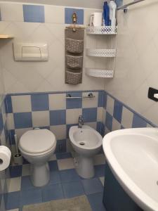 baño azul y blanco con aseo y lavamanos en Home del Conte, en Montecorice