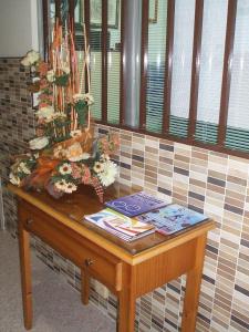 a wooden table with a vase of flowers on top of it at Hostal Casa Juan in Lorca
