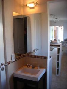 baño con lavabo y espejo grande en Pinamar Alquilo Frente Al Mar en Ostende