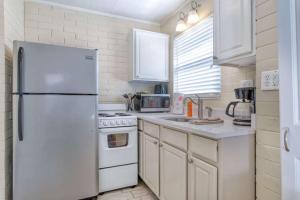 a kitchen with a white refrigerator and white cabinets at Mulberry Cottage in Siesta Key