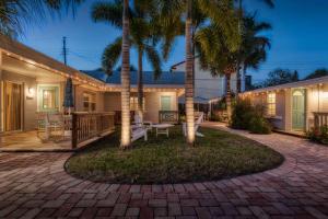 a house with palm trees and a patio at Mulberry Cottage in Siesta Key