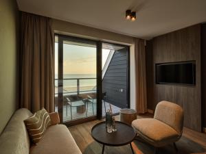 un salon avec vue sur l'océan dans l'établissement Hotel de Blanke Top, à Cadzand-Bad