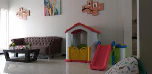 a living room with a toy house and a slide at Oemah Arma Rinjani 2 in Batu